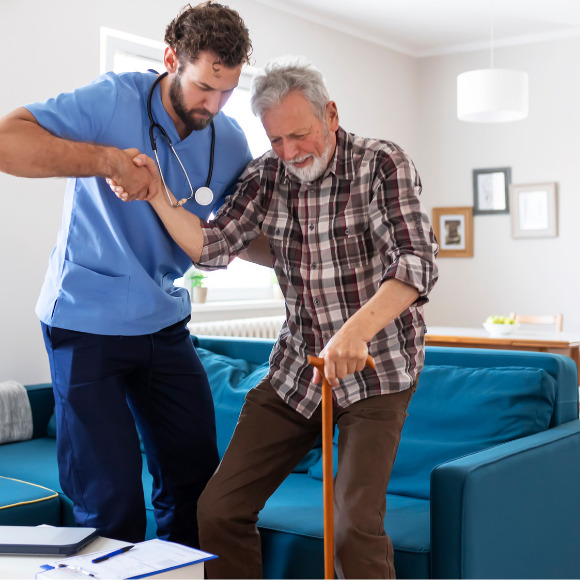 Jeune aide à domicile aidant un seniors à se lever